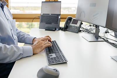 Männliche Person benutzt eine Tastatur am Computer
